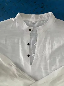 Close-up view of white linen Henley shirt showing mandarin collar and button detail