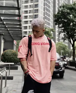 Camiseta rosa de hombre estilo streetwear oversize con diseño de King Kong en entorno urbano