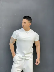 Detailed view of a men's premium white slim-fit athletic T-shirt on a fitness model