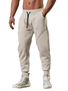 Men's beige sports joggers featuring a drawstring waist and stylish geometric panel stitching