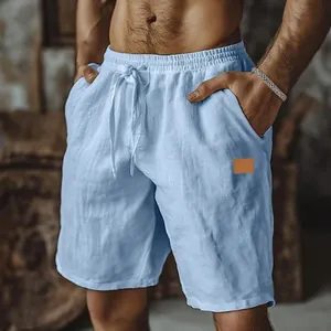 Close-up detail of men's light blue cotton linen shorts with drawstring waist and leather patch