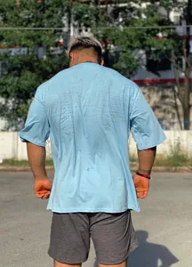 Vista trasera de una camiseta fitness azul claro oversize que muestra su ajuste holgado.