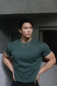 Athletic male model wearing a dark green slim-fit crew neck heavyweight fitness t-shirt