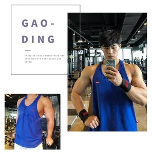 Detail view of a blue cotton fitness tank top on a male model in a gym setting