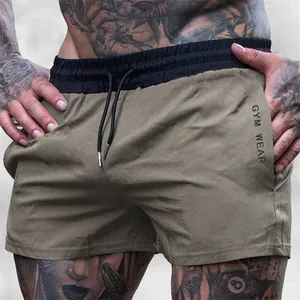 Close-up of olive green breathable athletic shorts with elastic waist and gym wear print