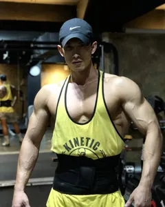 Detailansicht eines gelben Fitness-Tanktops aus Baumwolle, getragen von einem Bodybuilder