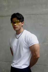 Male model wearing white crew neck heavyweight fitness T-shirt against concrete wall