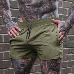Close-up detail view of olive green men's athletic shorts with Gym Wear print for gym training