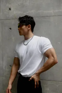 Detailed view of white slim-fit crewneck fitness T-shirt on a muscular male model