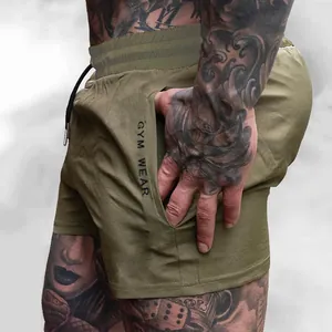 Close-up side pocket detail of men's olive green athletic gym shorts with print