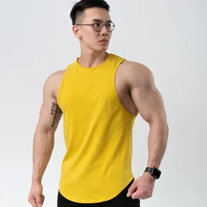 Close-up of a yellow cotton sports tank top for men showing the slim fit and curved hemline