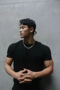 Close-up shot of a muscular male model wearing a black Sorona heavyweight crew neck T-shirt