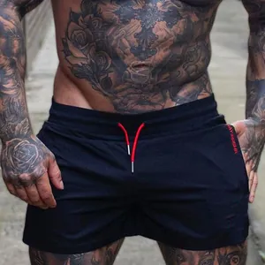 Detail of black men's sports shorts with red drawstring and side logo