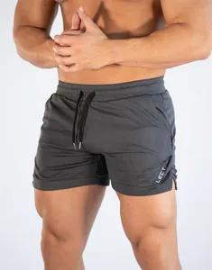 Detail der atmungsaktiven Mesh-Stoffstruktur und des Seitenschlitzes der grauen Laufshorts.