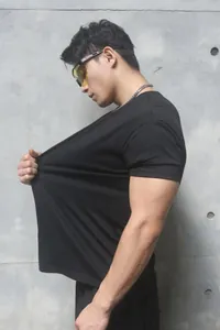 Close-up of athletic man stretching heavy Sorona fitness T-shirt to show elasticity
