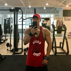 Nahaufnahme eines muskulösen Mannes im roten Fitness-Tanktop in einem Fitnessstudio