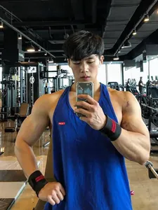 Breathable blue cotton fitness tank top for men, loose fit muscle vest in gym setting
