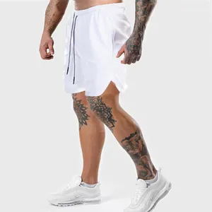 Dettaglio dei pantaloncini fitness bianchi da uomo con coulisse e spacchi laterali
