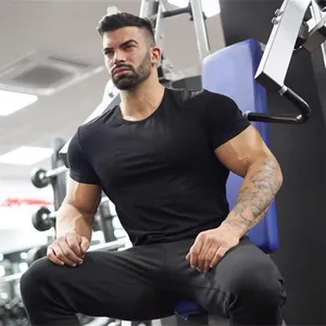 Man in a fitness gym wearing a black slim-fit cotton sports t-shirt for muscle training