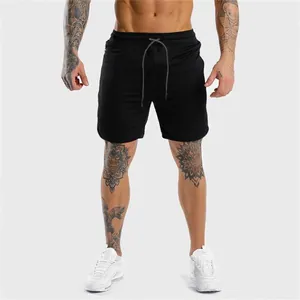 Vista frontale professionale di pantaloncini da fitness neri slim fit da uomo sul modello