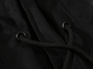 Nahaufnahme des schwarzen Hoodie-Kordelzugs mit Metallösen und Strickstoffstruktur