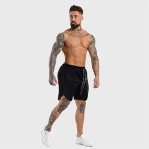 Modello maschile muscoloso che presenta pantaloncini fitness neri ad asciugatura rapida