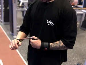 Détail de profil d'un homme portant un t-shirt de fitness noir en coton au gymnase