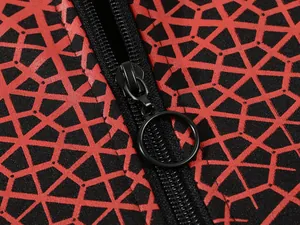 Detailaufnahme des schwarzen Reißverschlusses mit O-Ring an rotem Kapuzenpullover