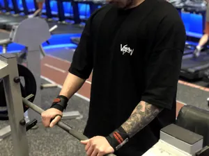 Gros plan d'un t-shirt de fitness noir en coton surdimensionné lors d'un entraînement