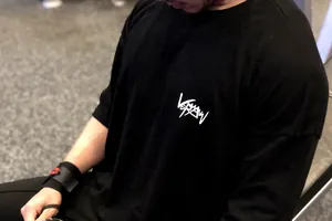 Gros plan d'un t-shirt de fitness en coton noir pour homme avec logo blanc sur la poitrine