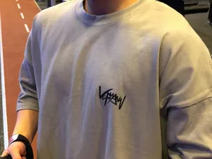 Vue détaillée d'un t-shirt de fitness gris en coton avec un logo noir élégant sur la poitrine