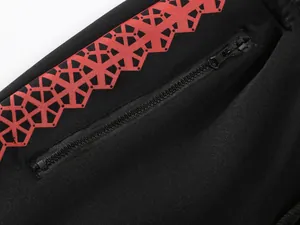 Nahaufnahme eines schwarzen Herren-Sweatshirts mit rotem Druck und Reißverschluss