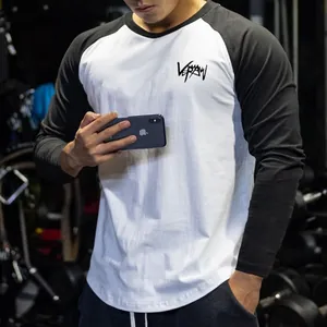 Close-up of men's black and white raglan long sleeve fitness shirt with chest logo
