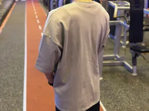 Vue arrière détaillée d'un t-shirt de fitness gris surdimensionné pour hommes en coton