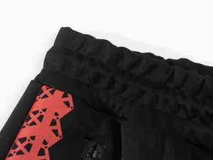 Nahaufnahme des elastischen Bunds und des roten Drucks auf der schwarzen Jogginghose