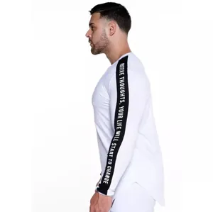 Side view detail of white athletic long-sleeved shirt with black sleeve text