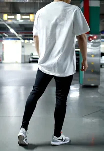 Vue arrière d'un t-shirt de sport blanc moulant pour homme dans un parking urbain