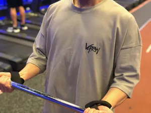 Gros plan d'un t-shirt de sport gris surdimensionné pour homme en coton lors d'une séance