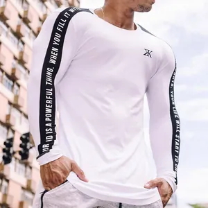 Detailed view of men's white compression gym shirt with typographic sleeve tape design