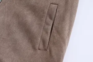 Macro view showing the fine suede texture and pocket stitching of a brown men's jacket.