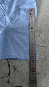 Close-up detail showing the measurement of a light blue cotton linen short sleeve shirt