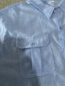 Close-up of men's blue cotton linen short-sleeve shirt with detailed pocket and button