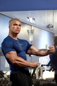 Macro view of a muscular male athlete flexing in a blue high-elastic compression gym sports t-shirt