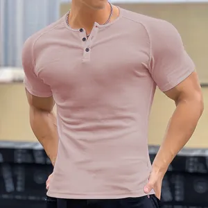 Close-up of pink ribbed Henley t-shirt showing muscle fit and button detail.