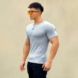 Side view of muscular man wearing slim fit grey ribbed Henley T-shirt in outdoor setting