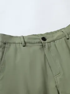 Close-up of men's woven shorts waistband featuring elastic back and button closure