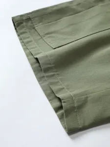 Macro view of army green woven fabric showing fine stitching detail on beach shorts