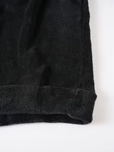 Nahaufnahme der weichen schwarzen Korallenvlies-Struktur eines Herren-Winter-Hoodies