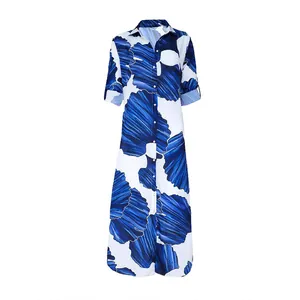 Robe chemise longue blanche à imprimé feuilles bleues avec col à revers élégant.