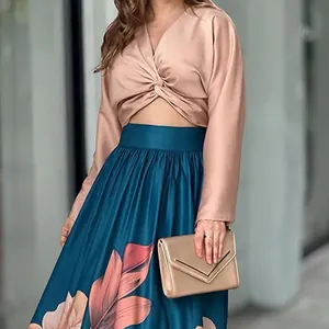Elegant women's two-piece set with a twist-knot crop top and a leaf-printed maxi skirt